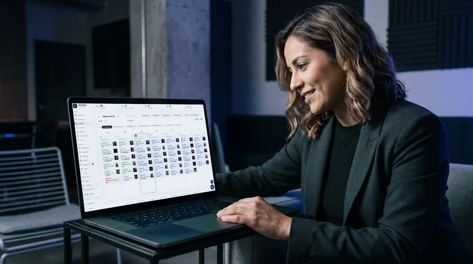 A woman reviews a content calendar on her laptop in a stylish co-working space.
