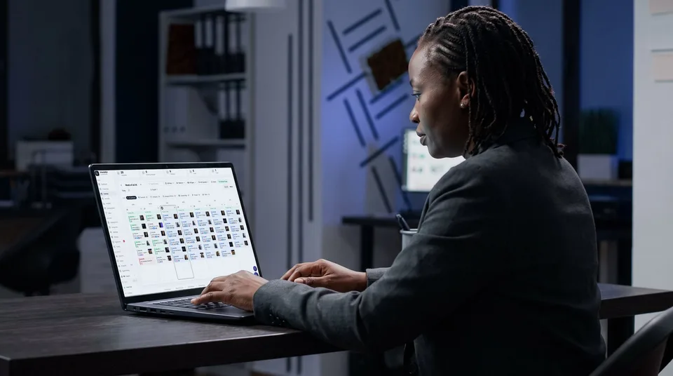 A woman reviews a weekly content calendar on her laptop in a stylish office.