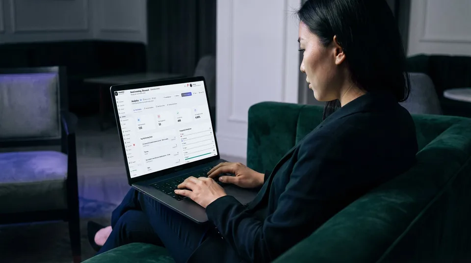 SchedulifyX analytics dashboard showing an engagement breakdown viewed on a laptop in a moody lounge.