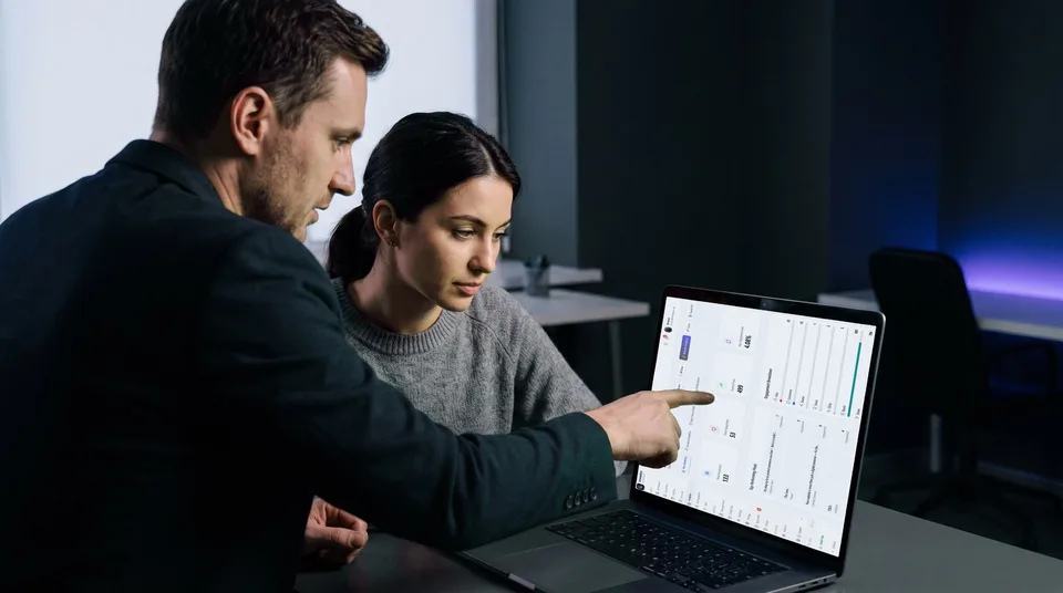 Colleagues reviewing an analytics dashboard on a laptop showing engagement breakdowns.